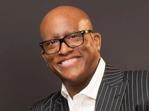 Portrait of Marquise Manns wearing glasses and a pinstripe jacket